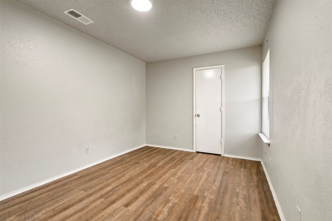 Spare room featuring wood finished floors, baseboards, and a textured ceiling | Image 17
