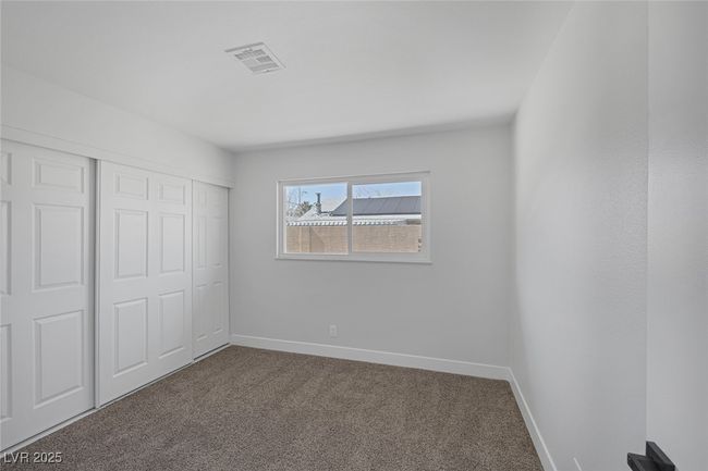 Unfurnished bedroom featuring dark colored carpet and a closet | Image 26