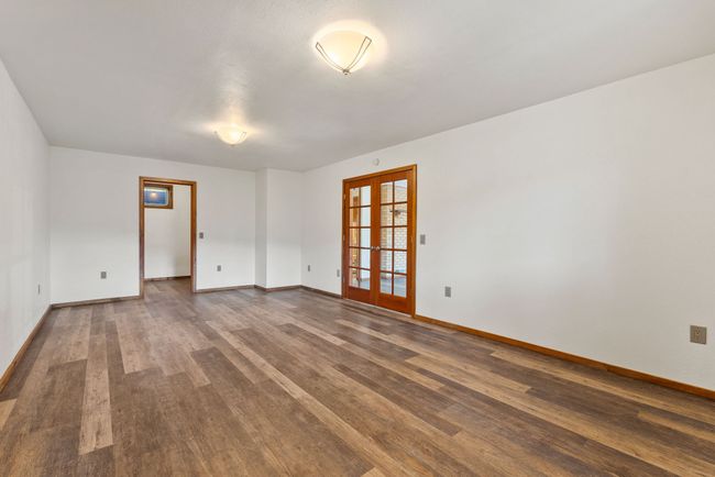 Lower level primary suite with french doors to covered patio | Image 38