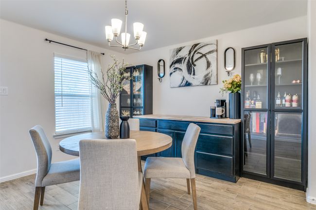 Dining space featuring light wood-style floors, a notable chandelier, and baseboards | Image 10