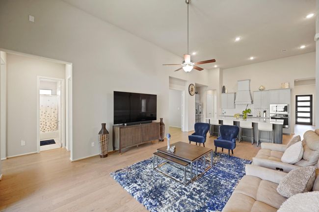 Living room features beautiful flooring, aceiling fan, high ceilings, and a wallof windows. | Image 16