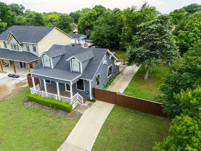 View of front of house with a porch, concrete driveway, and roof with shingles | Image 40