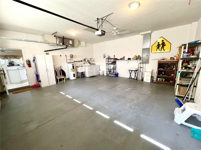 There is a laundry tub and a fan in the garage | Image 50