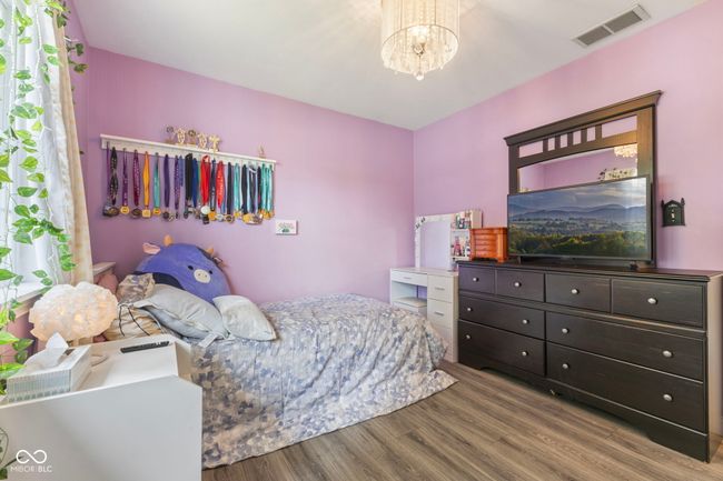 bedroom featuring wood finished floors and a chandelier | Image 17