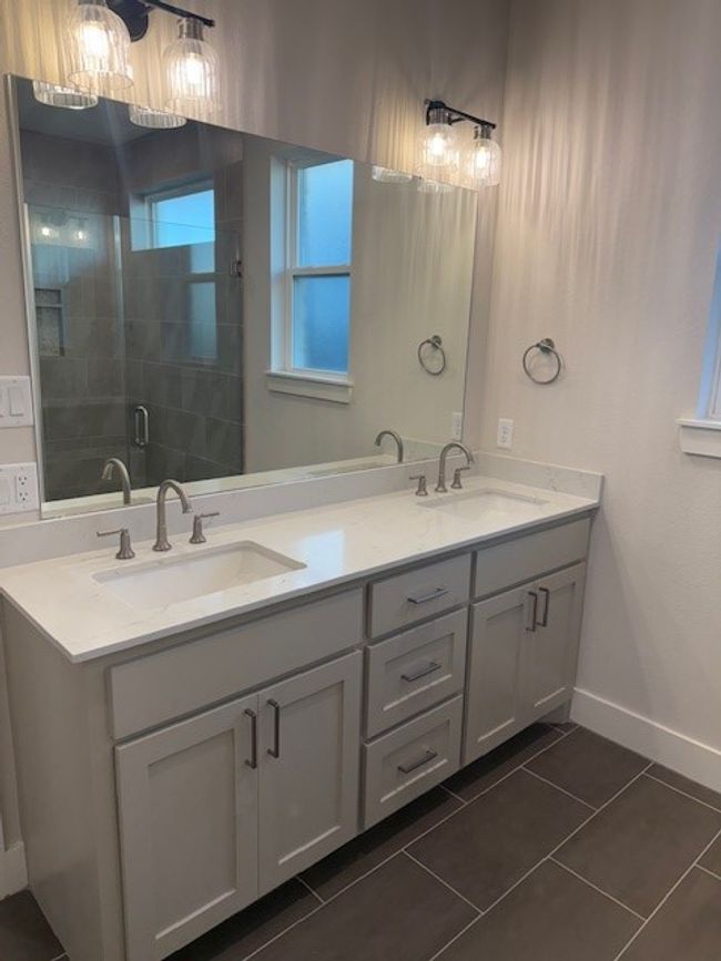 Bathroom featuring double vanity, a shower stall, and tile patterned flooring | Image 34