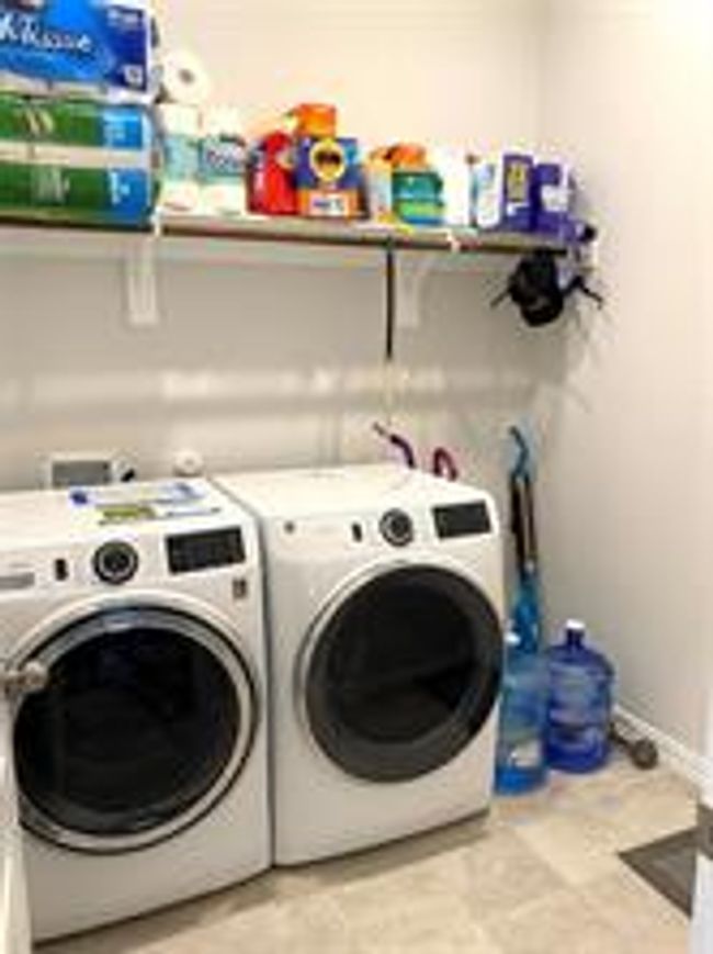 Washroom featuring washing machine and clothes dryer and baseboards | Image 24
