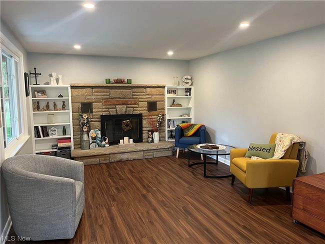 Living room with dark wood-type flooring, a wealth of natural light, and a fireplace | Image 7