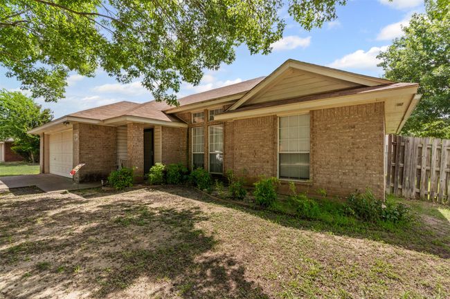 Ranch-style house featuring brick siding, driveway, and a garage | Image 4