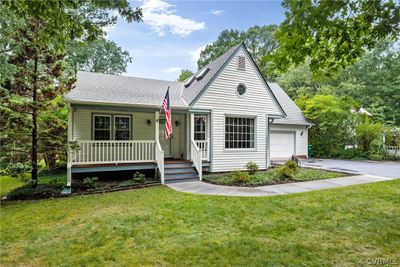 View of front facade featuring a garage, covered porch, and a front yard | Image 1