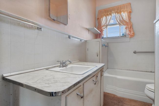 Full bath with toilet, a bathing tub, vanity, and tile walls | Image 22