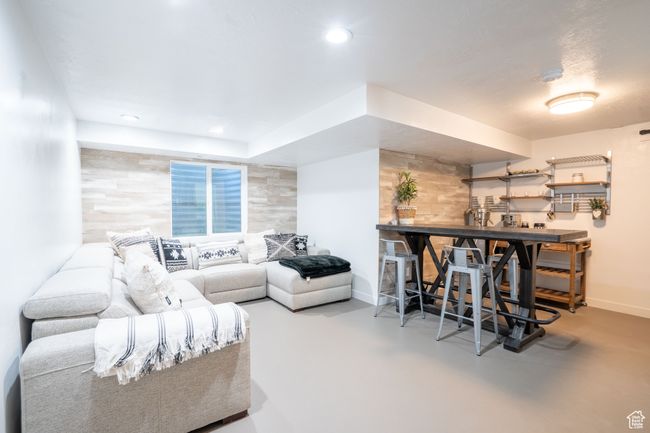 Basement living area with finished concrete flooring and recessed lighting | Image 29