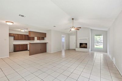 Spacious and inviting! The open-concept living and dining area in 8002 features a cozy fireplace and flows seamlessly into the kitchen on the far left. | Image 2