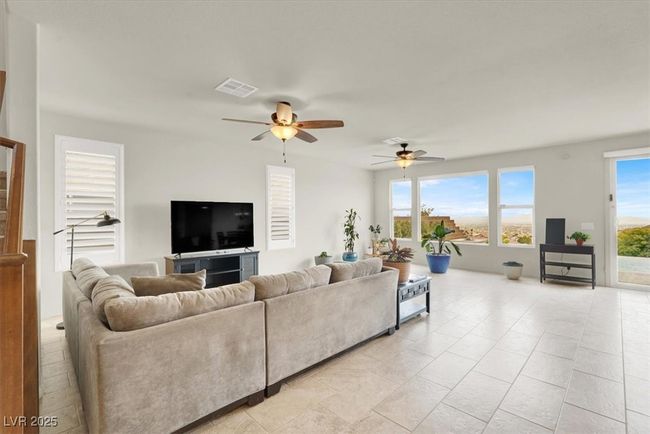 Living area featuring a ceiling fan and light tile patterned floors | Image 12