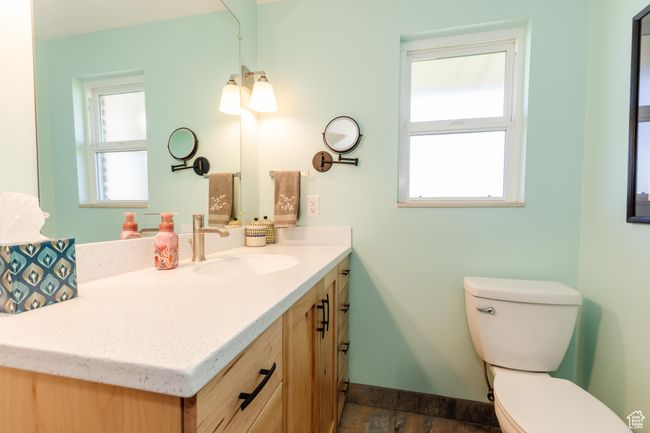 Half bath featuring baseboards, toilet, vanity, and a wealth of natural light | Image 19