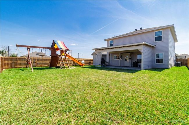 Back of property with a patio area, a playground, a lawn, and a fenced backyard | Image 19