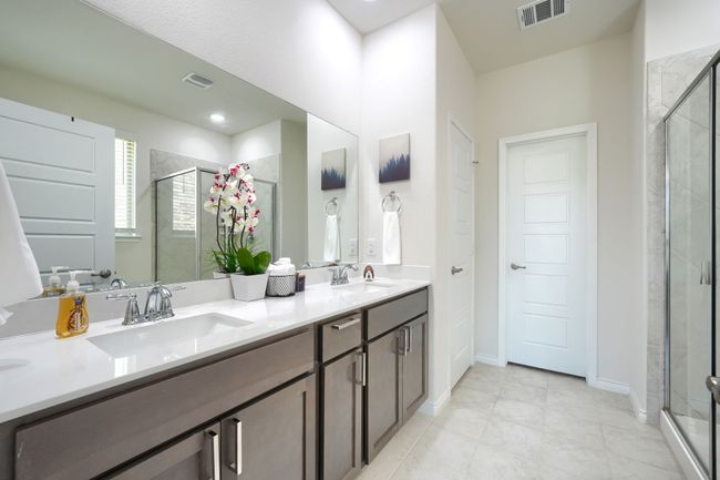 Bathroom with double vanity, a shower stall, and tile patterned flooring | Image 20