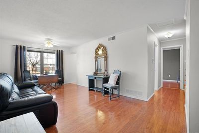 Enter to a wide open living room with hardwood flooring throughout and massive windows which provide an abundance of natural light! | Image 3