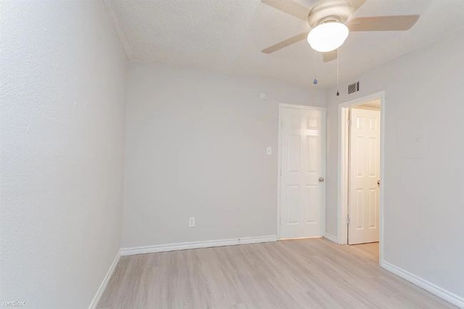 Spare room featuring light wood-style flooring and ceiling fan | Image 8