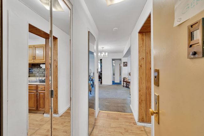 Hallway with light wood-type flooring and a chandelier | Image 13