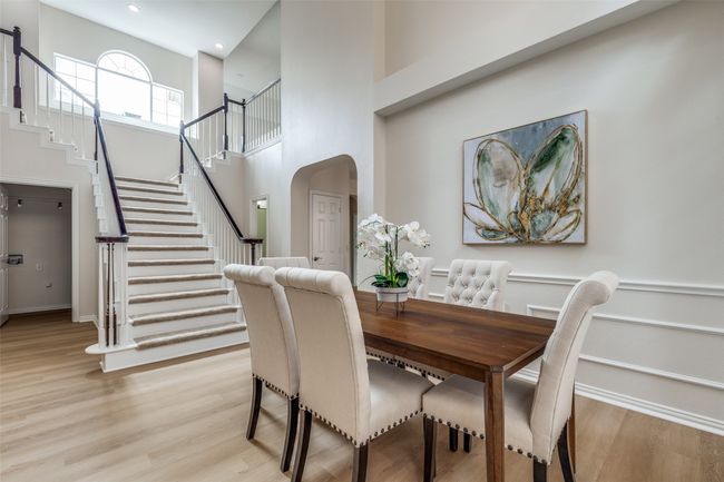 Dining space with stairs, a high ceiling, light wood-style floors, arched walkways, and recessed lighting | Image 6