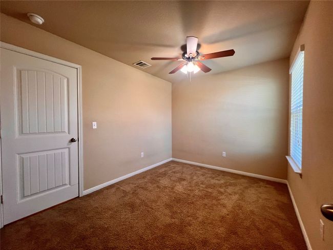 Carpeted bed room featuring a ceiling fan, plenty of natural light, and baseboards | Image 10