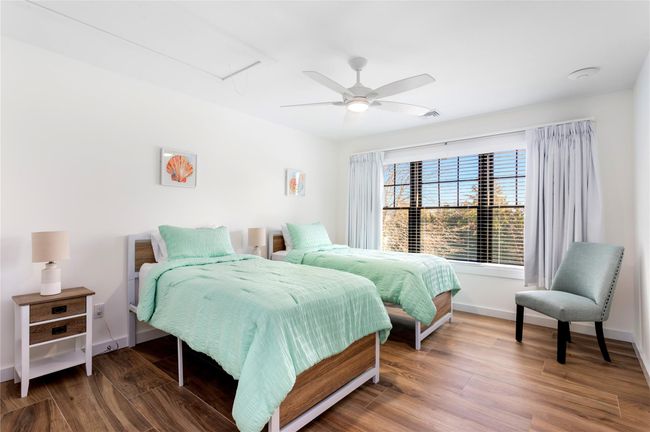 Bedroom with attic access, baseboards, ceiling fan, and wood finished floors | Image 21