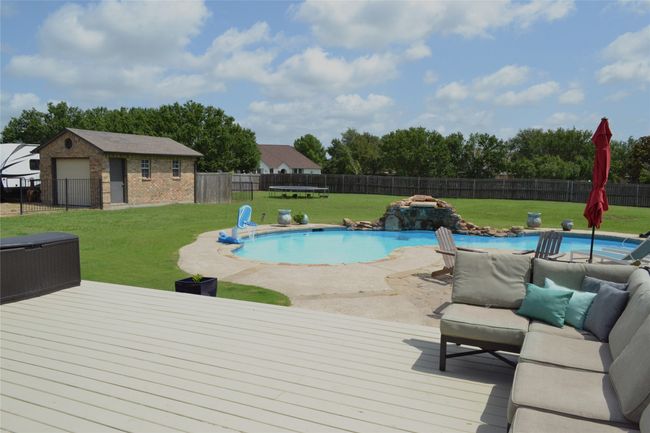 View of pool featuring a wooden deck and a fenced backyard, Shop | Image 35