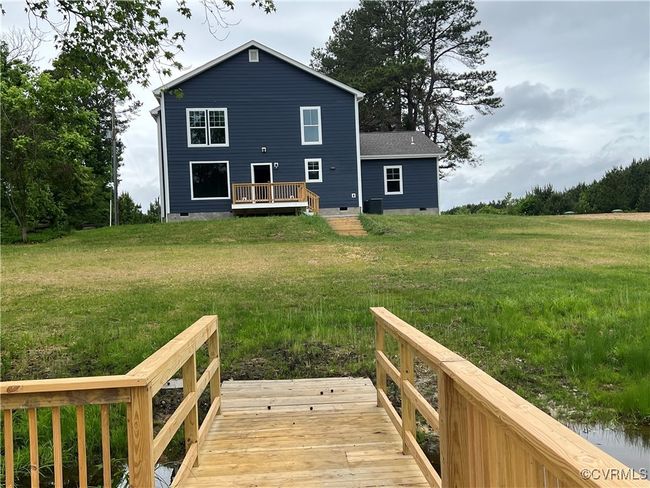 Rear view of property featuring a yard, a wooden deck, and crawl space | Image 42