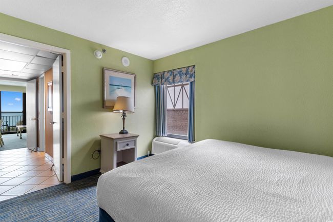 Bedroom with tile patterned flooring, a wall mounted AC, and baseboards | Image 21