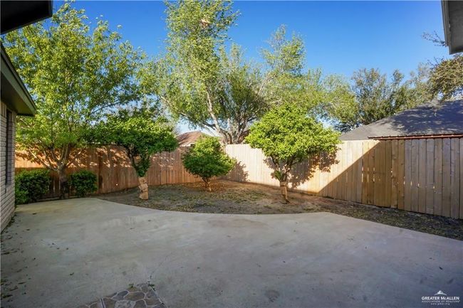 Fenced backyard with a patio | Image 10