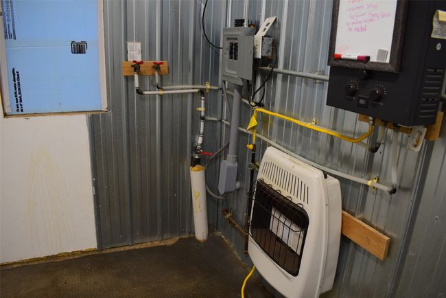 Utility room featuring heating unit and water heater | Image 75