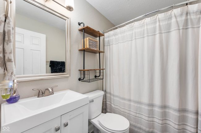 bathroom featuring toilet, vanity, and a shower with curtain | Image 16