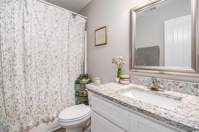 Bathroom featuring toilet, vanity, and a shower with shower curtain | Image 16