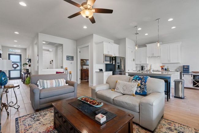 Living room with light wood-style flooring, ceiling fan, and recessed lighting | Image 11