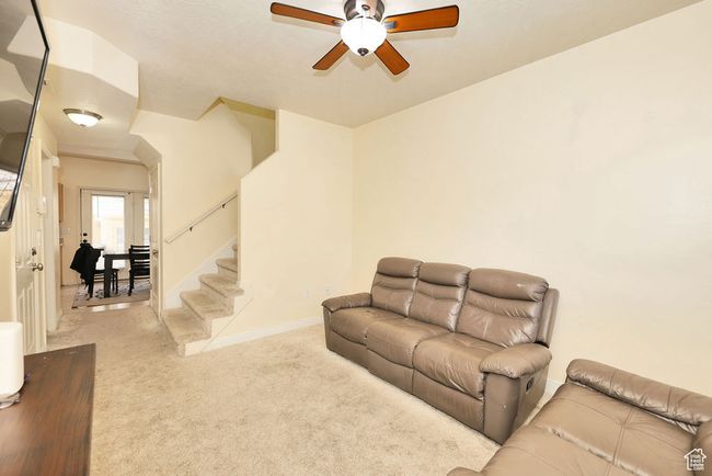 Living room featuring stairs, carpet flooring, baseboards, and a ceiling fan | Image 19