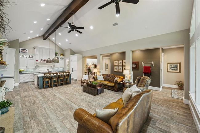 The living room is thoughtfully designed with two ceiling fans, recessed lighting, and a custom lighting system that allows you to create various ambiance scenes. This system can be easily controlled from your smartphone, offering both convenience and versatility in setting the perfect mood. | Image 13
