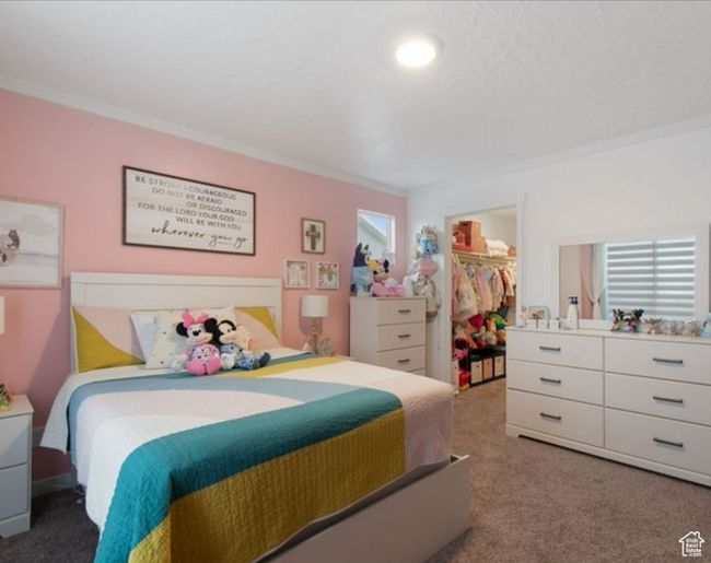 Bedroom featuring crown molding, carpet, a walk in closet, and a closet | Image 13