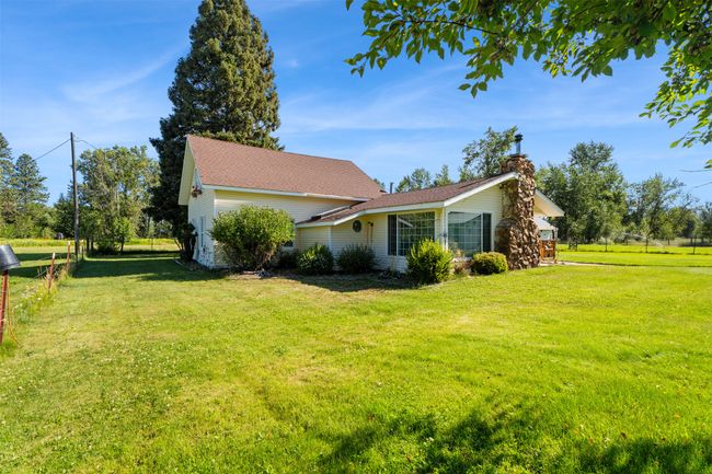 View of property exterior with a chimney and a shingled roof | Image 9