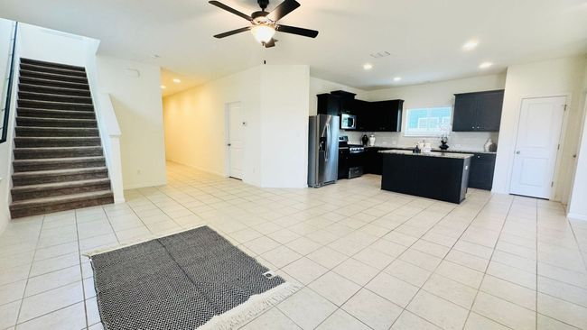 Kitchen featuring dark cabinetry, backsplash, a kitchen island, open floor plan, and stainless steel appliances | Image 11