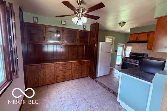 Charming kitchen and dining area with built-in cabinetry, tile floors, and direct access to the backyard. A functional layout with plenty of storage and natural light. | Image 5
