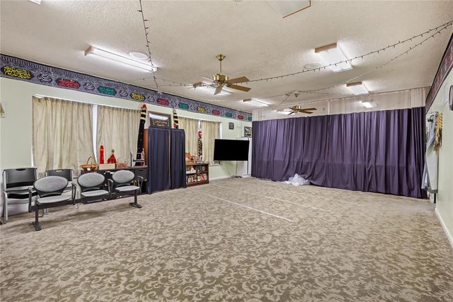 Misc room with a textured ceiling, carpet, and a ceiling fan | Image 30