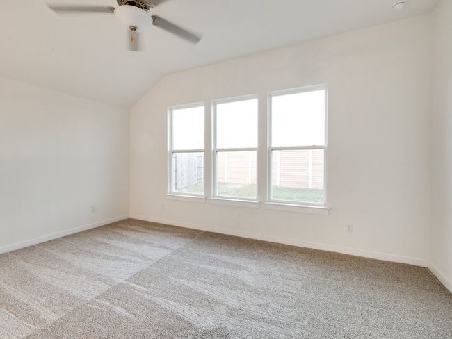 Carpeted empty room with vaulted ceiling, healthy amount of natural light, and ceiling fan | Image 28