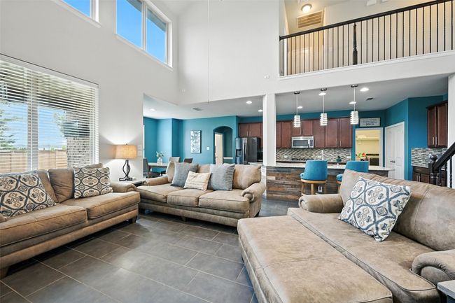 Living area featuring a towering ceiling, dark tile patterned flooring, and arched walkways | Image 8