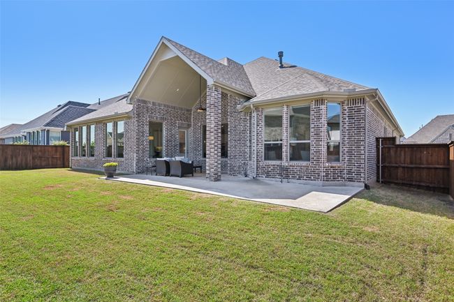 Rear view of house featuring brick siding, a patio area, and a fenced backyard | Image 38