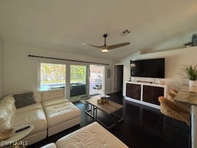Living room with a ceiling fan, visible vents, lofted ceiling, and wood finished floors | Image 9