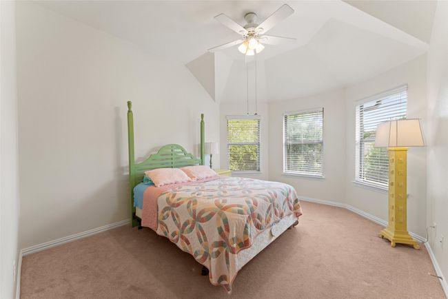 Bedroom featuring light carpet, lofted ceiling, and a ceiling fan | Image 29