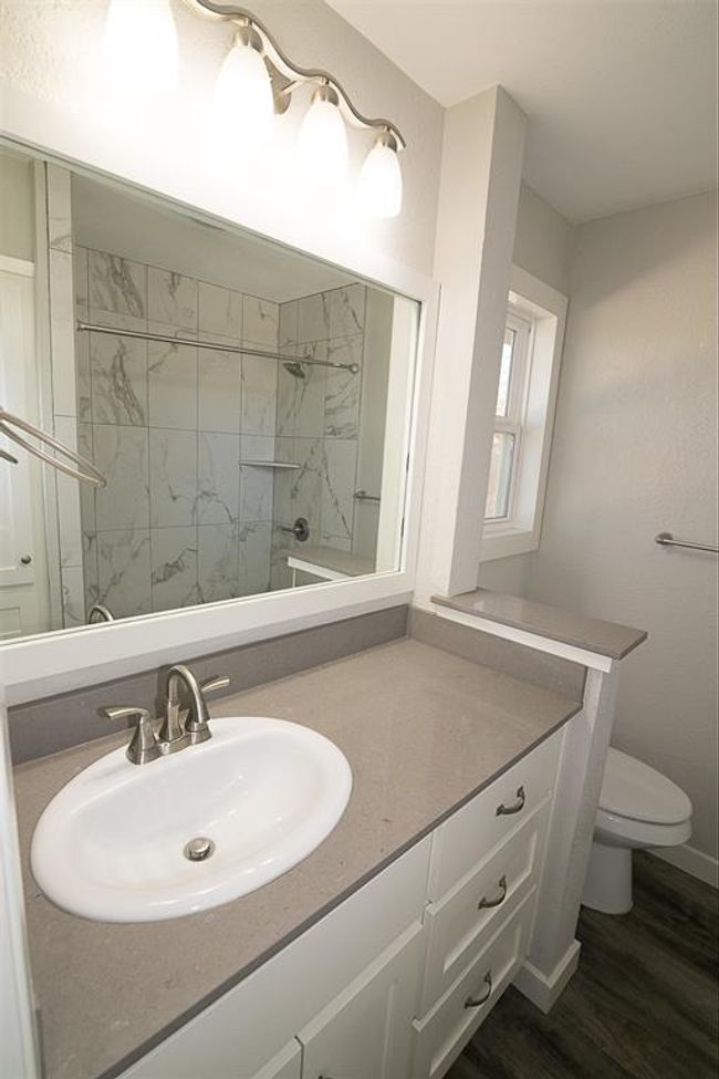 Full bath with vanity, a tile shower, and wood finished floors | Image 10