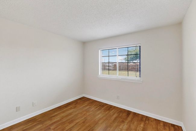 Empty room with wood finished floors and a textured ceiling | Image 28