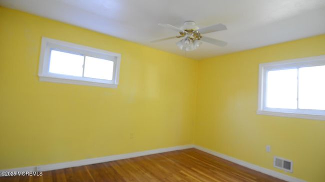 Bedroom 1 with Hardwood Floors and Mirrored Closet | Image 17