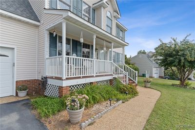 View of exterior entry featuring a garage, a yard, and covered porch | Image 2